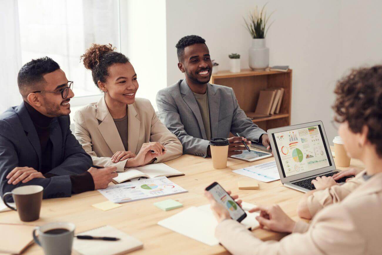 group of four employees discussing at a table