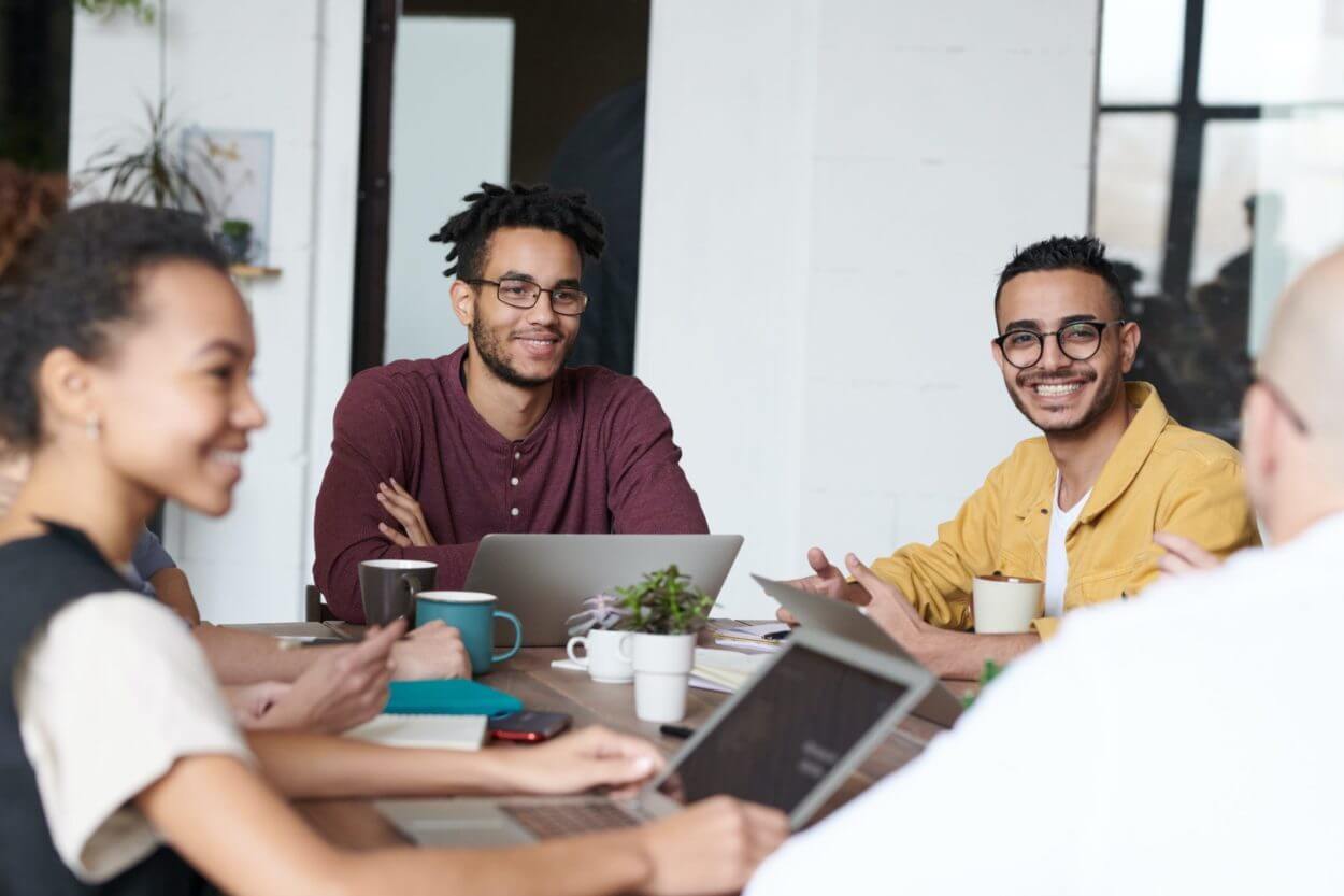 three employees at a table having a discussion