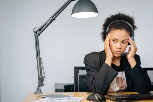 female worker at a desk looking stressed out