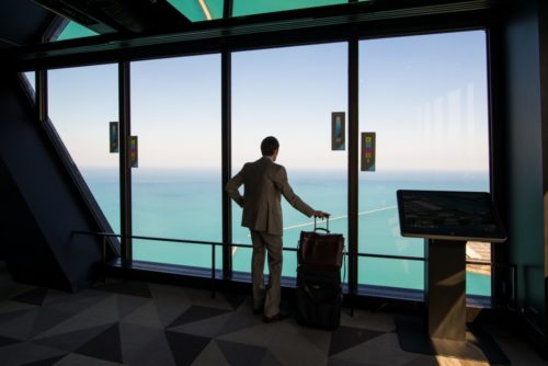 man with a suitcase near a large window