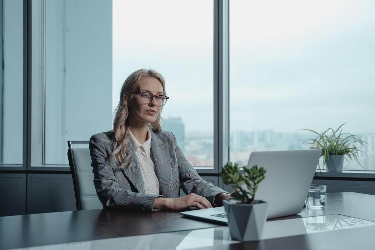 an executive at a desk typing a report on a computer researching work-life balance