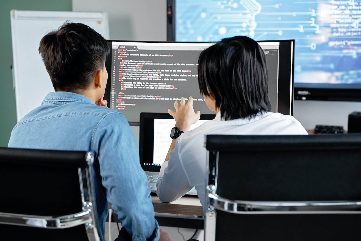 two professionals discussing generative ai and upskilling in front of a computer