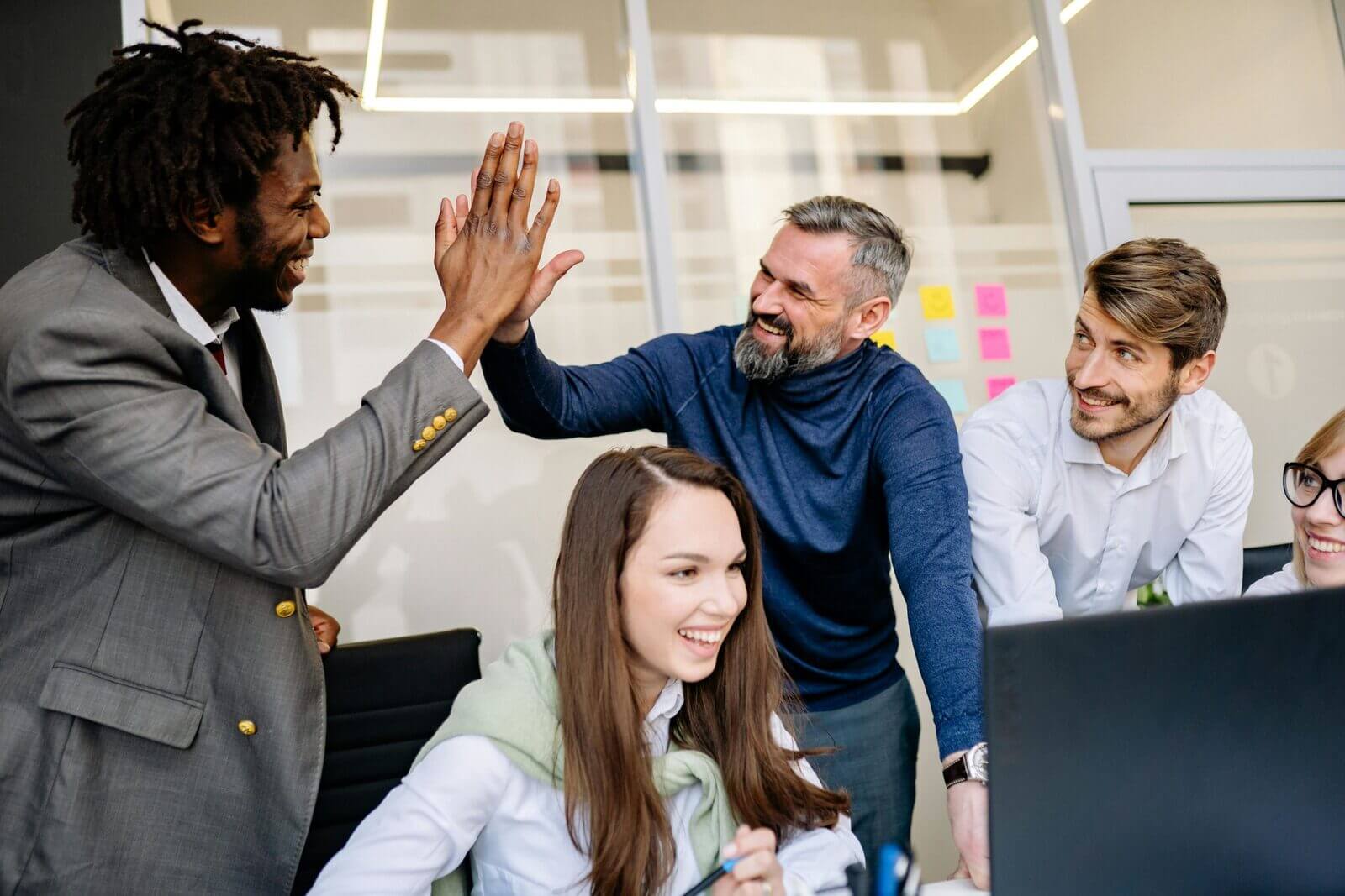 a team of workers high-fiving as their team leader masters employee appreciation