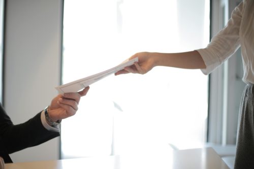 Person handing off resume to another person