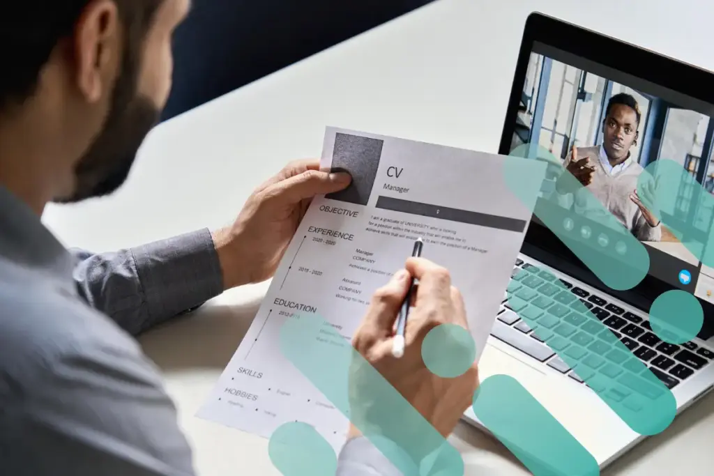 Manager reviewing an IT professional's resume at their desk with branding overlay.