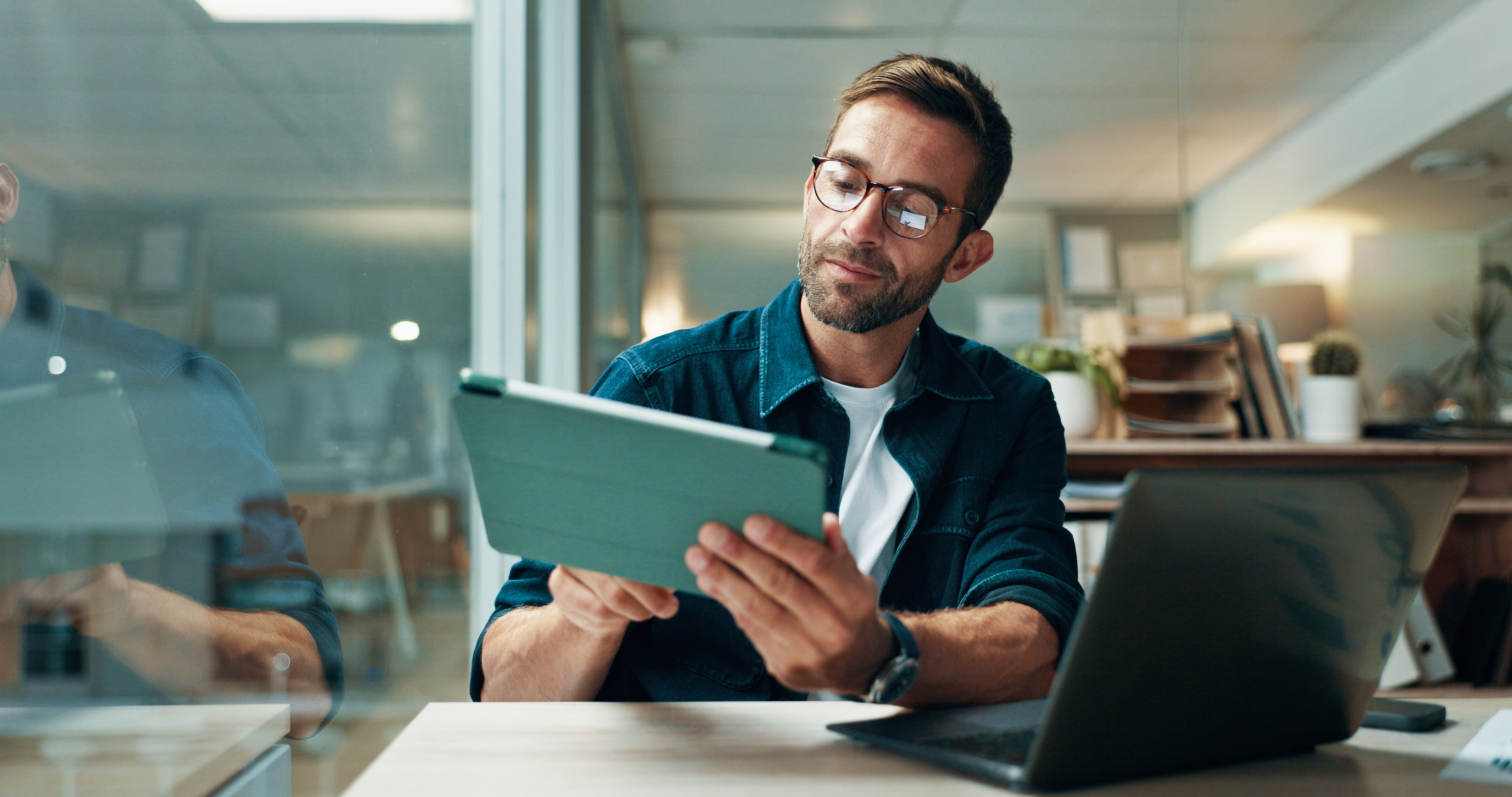 Tablet, glasses and laptop with business man in office for planning, ui designer and app review. Developer solutions, client feedback and research with person in agency for project idea and startup How AI Agents are Changing IT Staffing Priorities